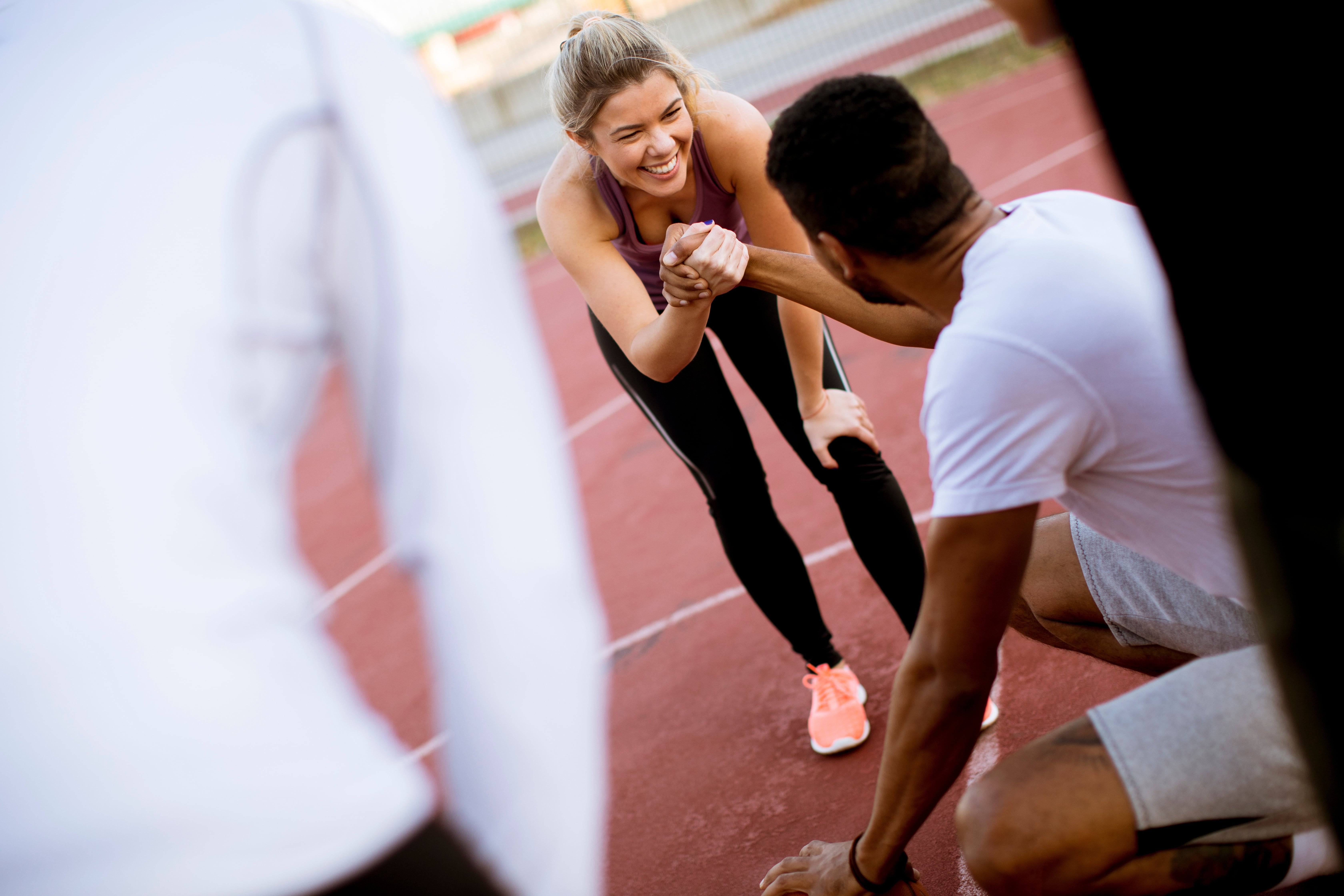 Mann und Frau schlagen auf dem Sportfeld ein. 