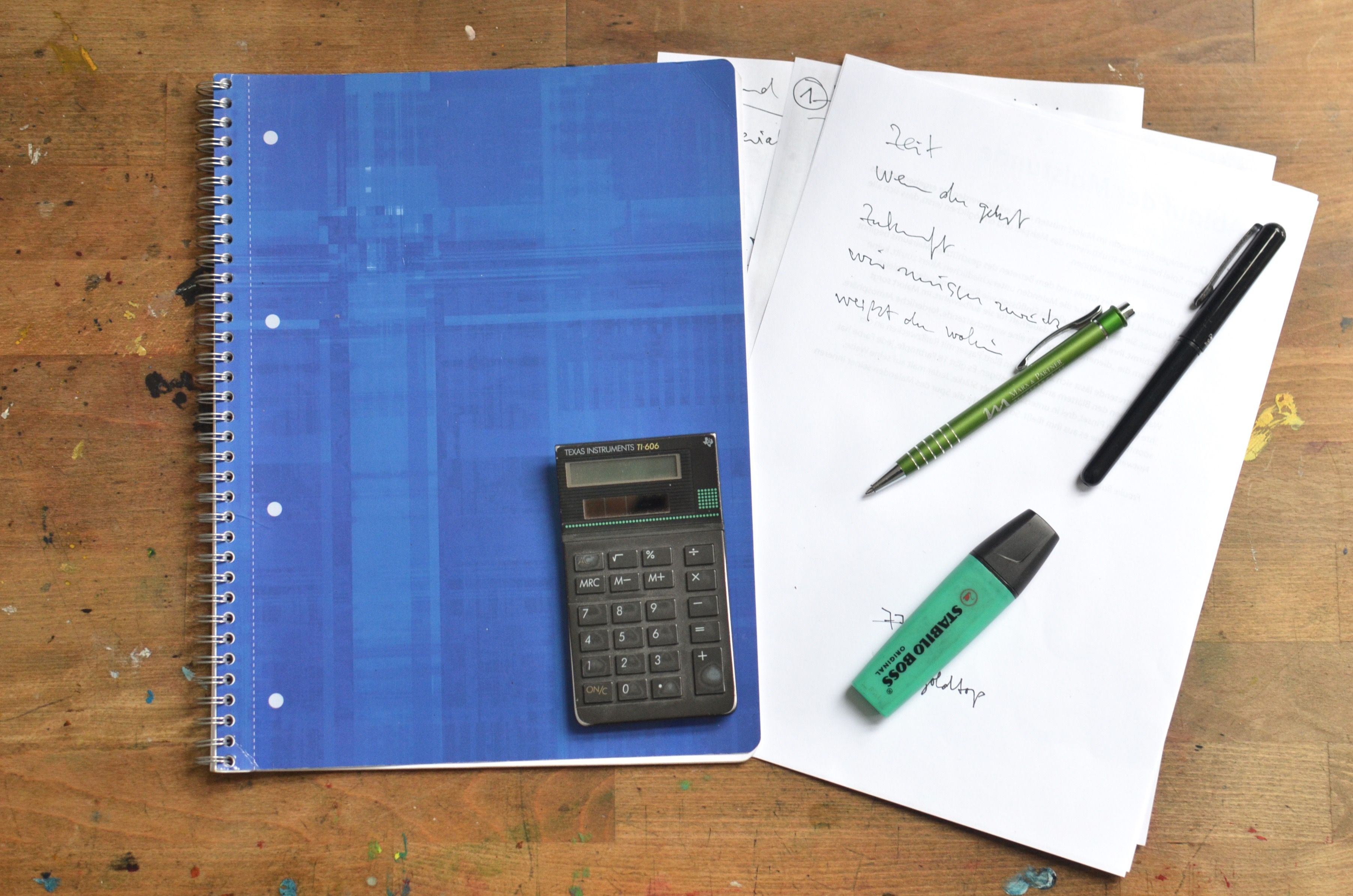 Schreibtisch mit Taschenrechner, Kulis und Hefte